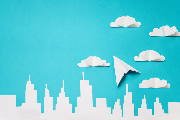 折纸飞机和云朵上的城市剪影。为横幅/登陆页/背景设计制作物品照片。图片下载