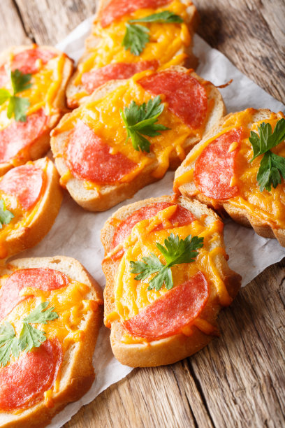 热烤面包，香肠和融化的奶酪切达干酪特写。垂直图片下载