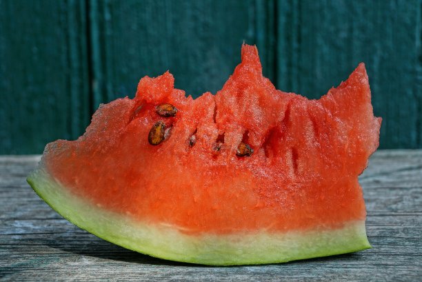 灰色的桌子上放着一大块又红又熟的西瓜图片下载