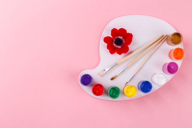 彩色的水彩调色板和画笔在粉红色的背景图片下载