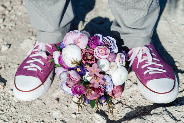 婚礼细节以紫色球鞋和紫色婚礼花束的形式呈现。图片下载