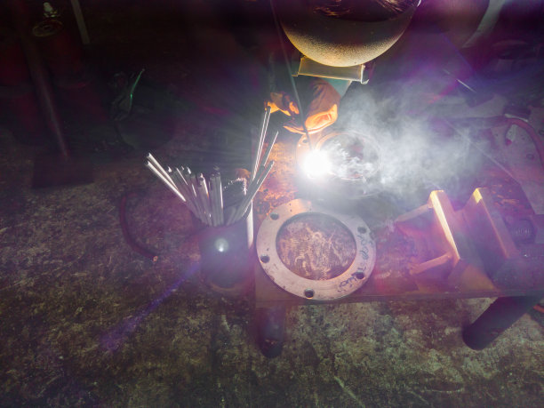 靠近工人焊接钢与烟雾和五颜六色的灯光图片下载