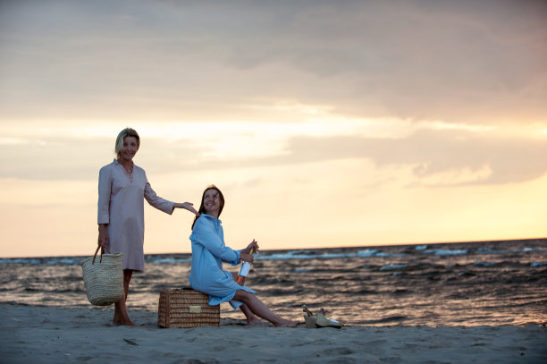 两个年轻女人在海边玩，喝着酒图片下载