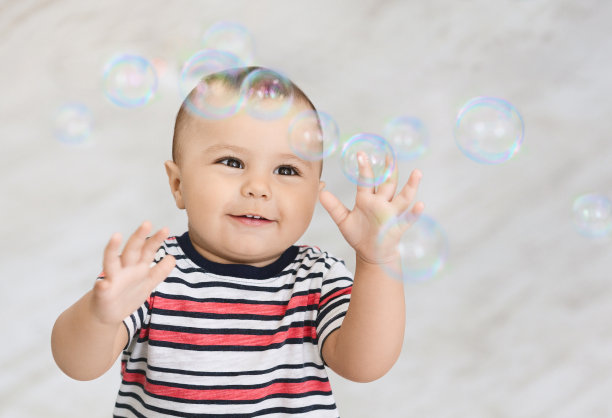 可爱的小男孩玩着许多肥皂泡图片下载