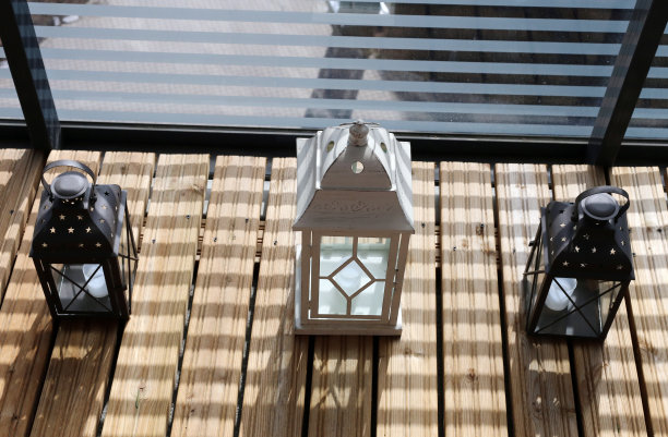 阳台上木质地板上的白色和棕色灯笼图片下载
