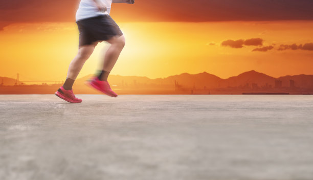 健康的生活方式和减肥。一个年轻人在夏日日落的水泥路上奔跑图片下载