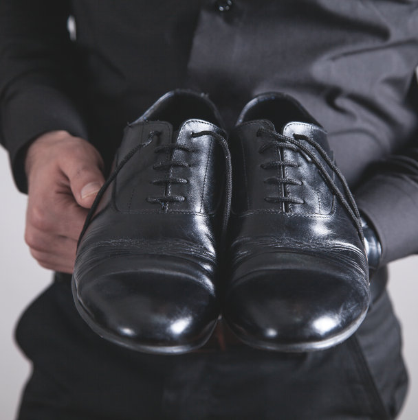 拿着黑鞋的男人。时尚的概念图片下载