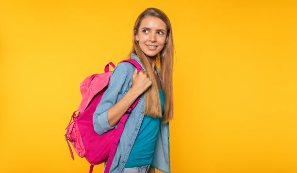 学习、教育、大学、学院、毕业观黄背景。美丽微笑的金发女人的肖像。背着背包的年轻学生图片下载