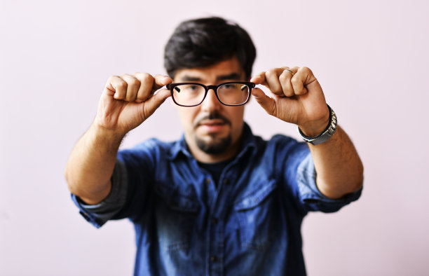 一个拿着眼镜的男人的特写图片下载