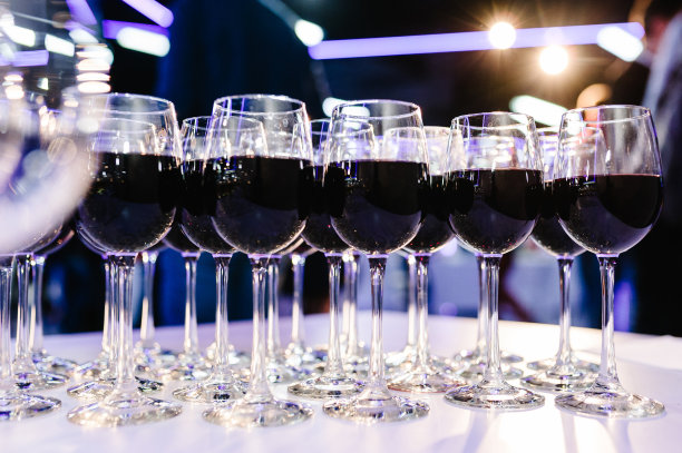 桌上放着一杯红酒。吧台上有许多玻璃杯葡萄酒。眼镜和酒。填满了一半，站在节日的桌子上。Furshet。图片下载