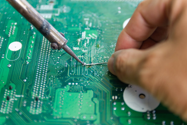 技术人员正在用烙铁修理计算机电路板的电子元件图片下载