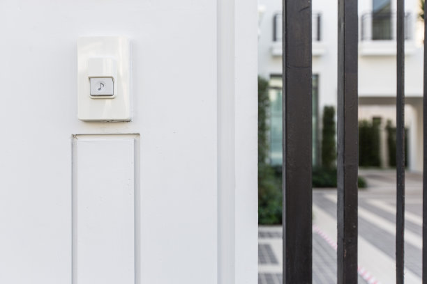 门铃在白色的墙壁和大门上响起图片下载