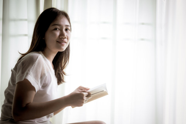 年轻女子在读一本书。图片下载