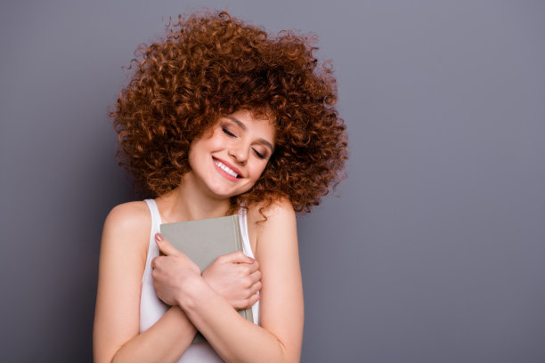 近距离拍照的狐狸精女士读者书虫拿着最喜欢的小说近大喜穿白色背心孤立的灰色背景图片下载