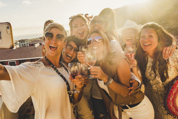 幸福的概念，白人年轻女性朋友笑和有乐趣在一起的友谊与智能手机自拍照片-太阳在背光和视图图片下载