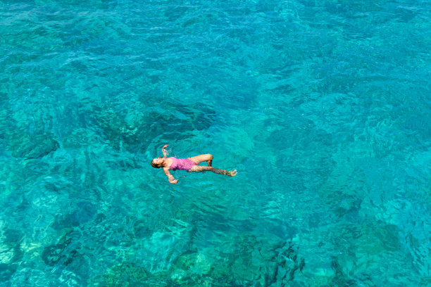 女人漂浮在纯洁的海洋。图片下载