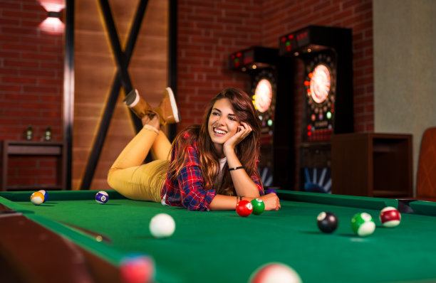 一个女孩的肖像躺在桌上打台球图片下载