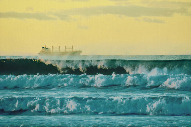 有意模糊的背景图像-油画效果。日落时美丽的海景，远处还有一艘货船。图片下载