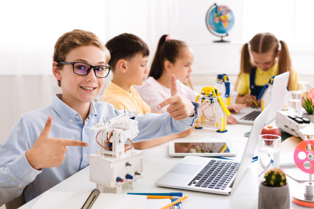 男孩展示他的机器人。他的项目的骄傲学生图片下载