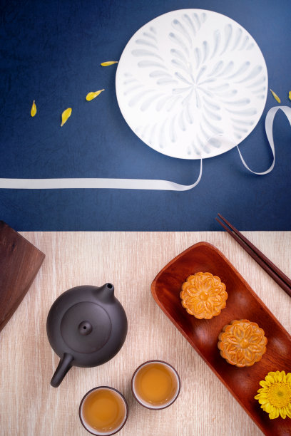 创意月饼月饼设计灵感，用糕点和茶水在木桌上享受中秋节的月亮图片下载