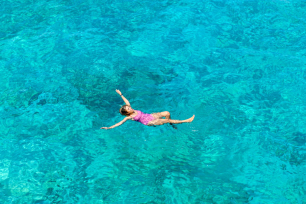 女人漂浮在纯洁的海洋。图片下载