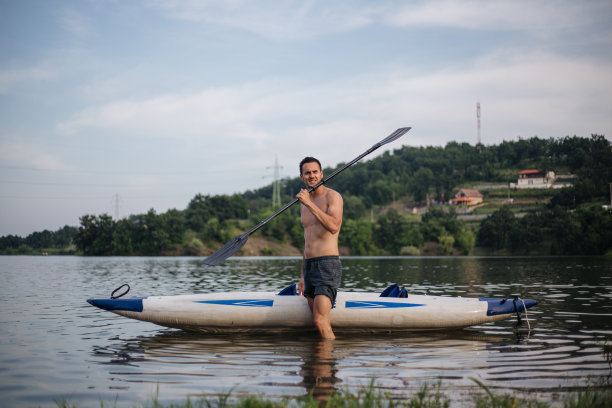 手里拿着桨的男人站在那里图片下载