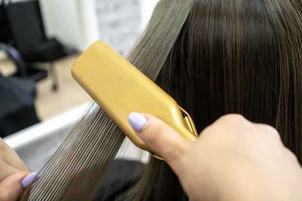 可爱的女孩与长黑发发型师做头发分层在美容院。护发治疗理念，特写图片下载