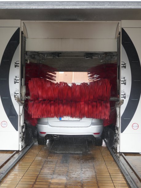 汽车下的旋转洗车刷在自动洗车。图片下载