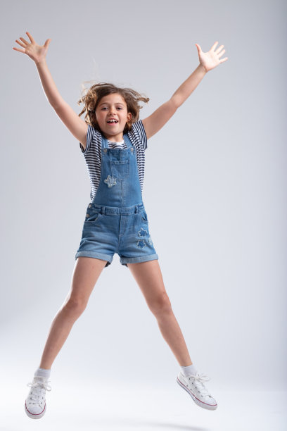 运动员般苗条的年轻女孩在空中跳跃图片下载