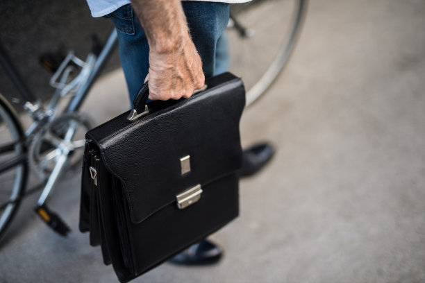 一个不知名的高级男子拿着公文包近距离工作。图片下载