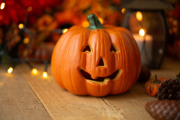 万圣节南瓜与树叶在一个旧木桌与发光灯和一个旧灯。秋天的心情和大气的照片图片下载