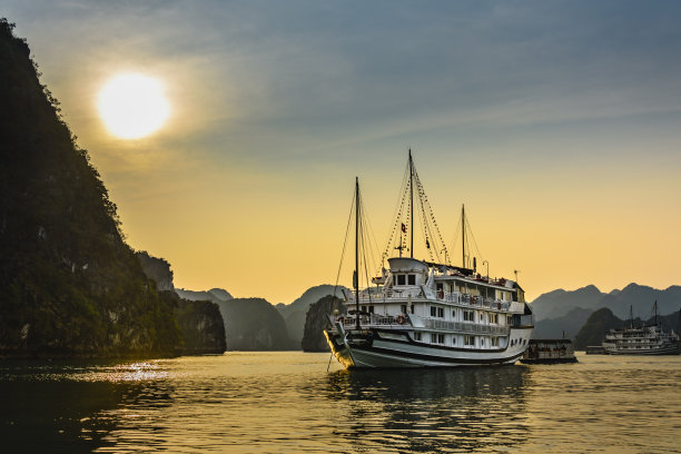 日落时分，越南下龙湾的观光游船图片下载