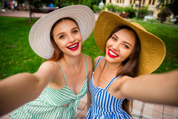 近距离的照片迷人的学生深色头发有红色发油坐在格子毯子上在草坪户外图片下载