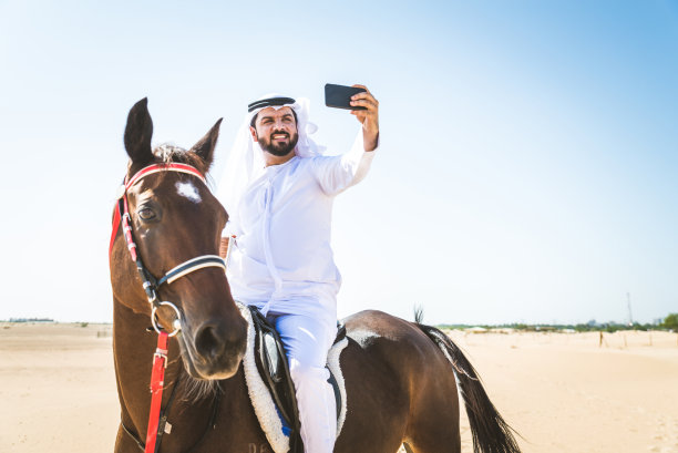 沙漠里骑着马的阿拉伯人图片下载