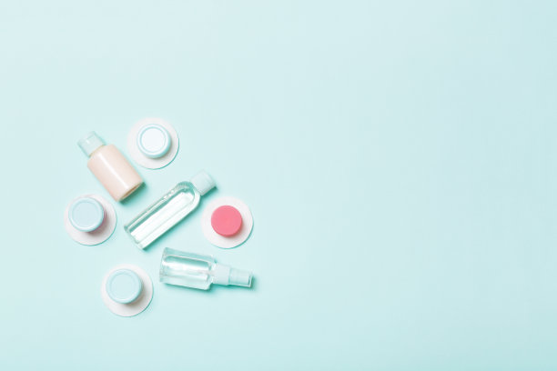 面部护理方法俯视图:瓶子和罐子的滋补，胶束洁面水，霜，棉垫在蓝色的背景。身体护理概念与空的空间为您的想法图片下载