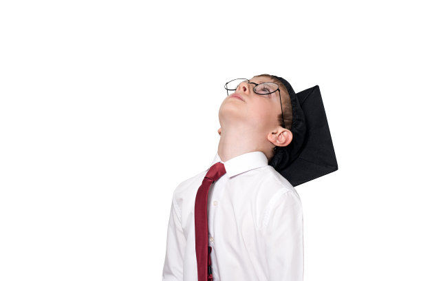 男孩戴着方正的学术帽和眼镜向上看。学校的概念。隔离图片下载