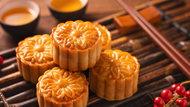 中国传统糕点月饼竹制托盘上的茶杯月饼木制背景中秋节。图片下载