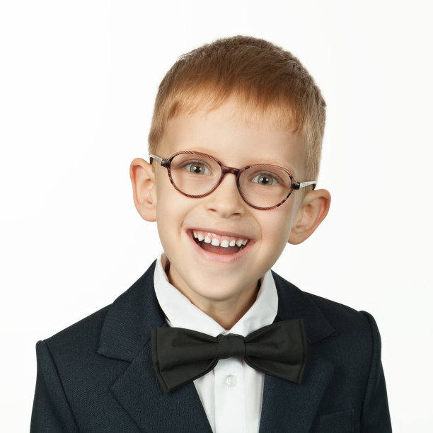 一个7岁的红发男孩戴着眼镜，穿着校服，背景是白色图片下载