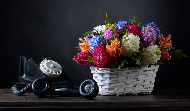 一束风信子在一个白色的篮子和一个黑色复古手机。图片下载