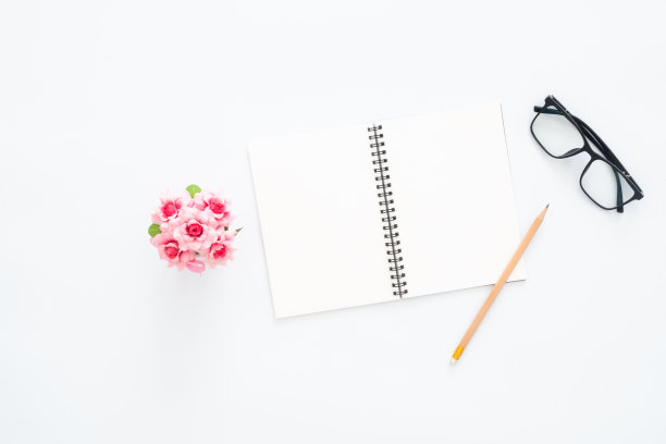 创意平面办公桌照片。顶视图办公桌，眼镜，铅笔，空白笔记本和植物在白色的背景。顶视图与复制空间，平铺摄影。图片下载