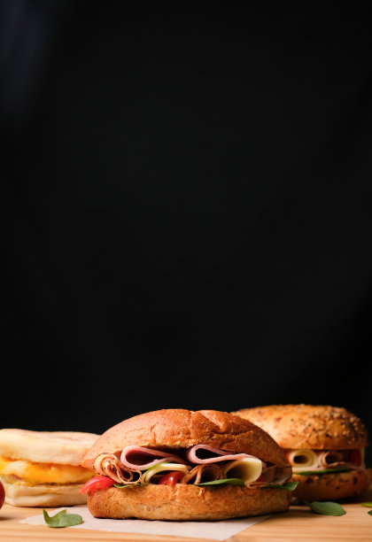 美味的经典blt三明治搭配火腿，奶酪，培根，西红柿。早餐和快餐。在孤立的黑色背景木和文本复制空间。图片下载