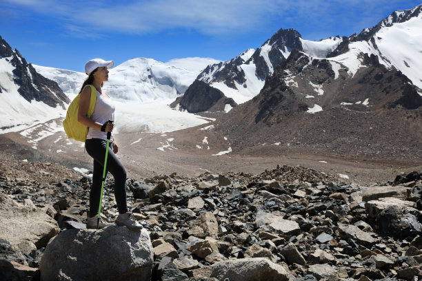 年轻女子徒步旅行者背包在山上冰川图片下载