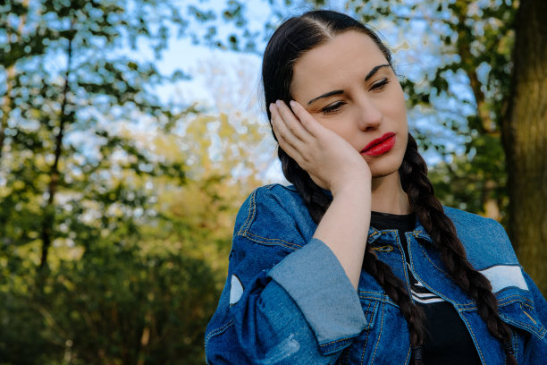 孕妇头痛。女人紧紧地抱着她的头，她感到很痛。图片下载