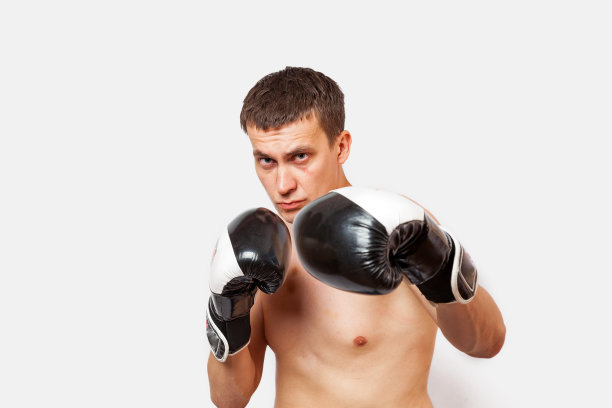一名戴着拳击手套的男子在一场打斗和拳击中被刺伤，他的身体和面部都有瘀伤，背景是白色的图片下载