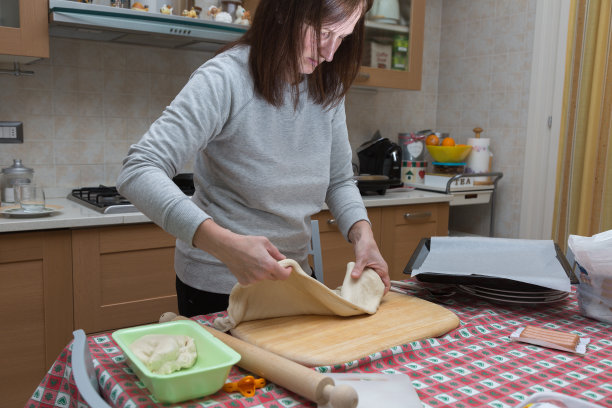 在家准备披萨:一个女人在厨房做美味的披萨图片下载