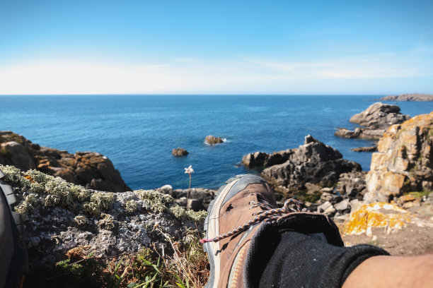 步行者正在尤岛的岩石海岸休息图片下载