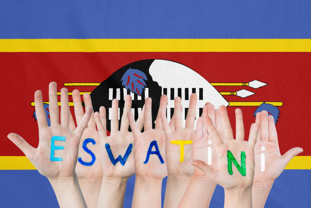 在挥舞的斯瓦蒂尼旗帜的背景下，孩子们的手上刻着斯瓦蒂尼语图片下载