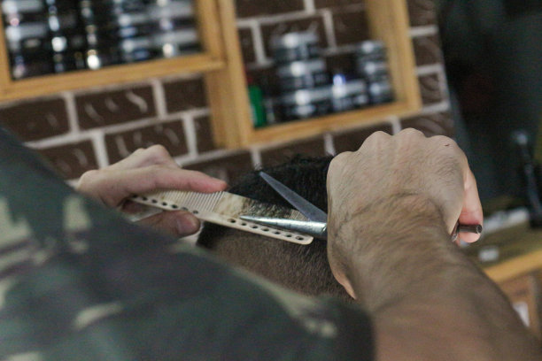 用梳子和剪刀剪头发的手图片下载