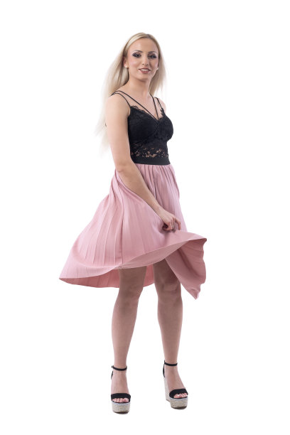 金发年轻女子在夏天时髦的衣服跳舞和旋转在风的运动。图片下载