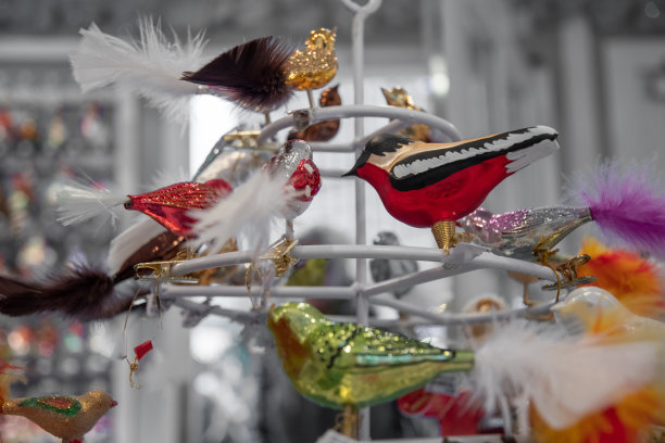 有羽毛尾巴的各种鸟形状的玻璃圣诞装饰品。照片与冷色滤镜。复古风格的节日装饰。德国柏林的圣诞集市。新年的庆祝活动。图片下载